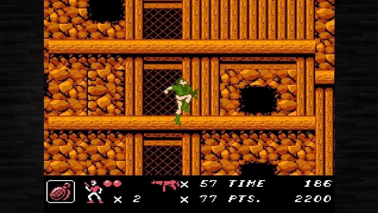 A green-clad soldier character stands on a wooden platform within a multi-level interior structure. The background features orange and brown stone brick walls with dark mesh-pattern windows and black openings. Wooden beams separate three visible floor levels. The HUD displays at bottom left a round bomb icon, a soldier counter showing two units, and text reading "57 TIME" and "186" in the upper right, with "77 PTS." and "2200" displayed below. The sprite uses bright green, white, and tan colors typical of early NES-era pixel art.