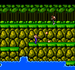 A horizontal scrolling jungle level displays two armed soldiers standing on green platform terrain amid dense brown and green foliage. Multiple rows of gray stone blocks form the landscape structure, with a blue water area visible at the bottom. Tall green palm trees line the upper background, creating a layered parallax effect. The sprite-based graphics use a limited NES-era color palette with distinct pixelated character and environmental elements rendered at low resolution.