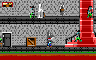 A pixelated side-scrolling level displays a mansion interior with a blue-clad character standing on a black platform in the center. Gray stone walls with a crosshatch pattern form the background, while wooden crates and doors occupy the lower level. A tall red staircase rises on the right side, and green zombie-like enemies appear in the upper-left and upper-right areas. The top-left corner shows a score display with a red background. A green grass strip runs along the bottom edge, and the overall color palette consists of muted grays, reds, greens, and browns typical of early-1990s DOS-era graphics.