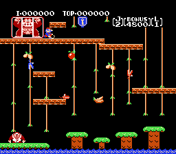 A platformer level featuring a young monkey character on the left side of the screen, surrounded by vertically-arranged wooden beams, chains, and vines suspended from above. The playfield spans multiple tiers with brown wooden platforms and orange rope structures. At the bottom, green foliage and brown platforms form the ground level. The top displays a pixel-art score readout showing points, level information, and status indicators. The background is solid black, and all sprites use limited color palettes typical of early 1980s arcade-style graphics.