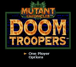 The title screen displays 'Mutant Chronicles: Doom Troopers' in large orange and gold lettering centered on a black background, framed by a green rectangular border. Below the title, white text reads 'One Player' and 'Options'. The logo features ornate gold typography with a crown-like emblem above the main title text. The overall color scheme uses gold, green, and black against the dark background, typical of early-to-mid 1990s SNES-era sprite-based graphics.