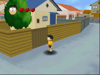 A child character in yellow stands on a snowy street in the center of the screen. Behind them is a wooden fence with a gate, and residential houses with blue doors and red-tiled roofs line both sides of the path. A green tree with a character portrait and three red hearts appears in the upper-left corner. The scene uses early Nintendo 64-era 3D graphics with low polygon models and a clear sky visible overhead.
