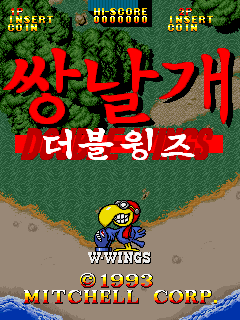 The title screen displays large red Korean text reading "쌍날개" (Double Wings) centered on a green foliage background. Below sits a small yellow and blue sprite character positioned above gray terrain. The top of the screen shows score and credit text in white and yellow. At the bottom, white text reads "1993 MITCHELL CORP" with a blue water wave graphic beneath. A copyright notice appears in the lower left corner.