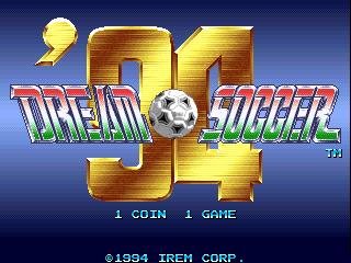 The title screen displays 'Dream Soccer '94' in large gold and red lettering against a dark blue gradient background. A yellow soccer ball sits between the two large '9' numerals forming the year. Below the title text, white letters indicate '1 COIN 1 GAME'. At the bottom, copyright text reads '©1994 IREM CORP.' in small white font. The overall composition uses a 16-bit sprite aesthetic with metallic gold-colored text elements and a clean arcade cabinet layout.