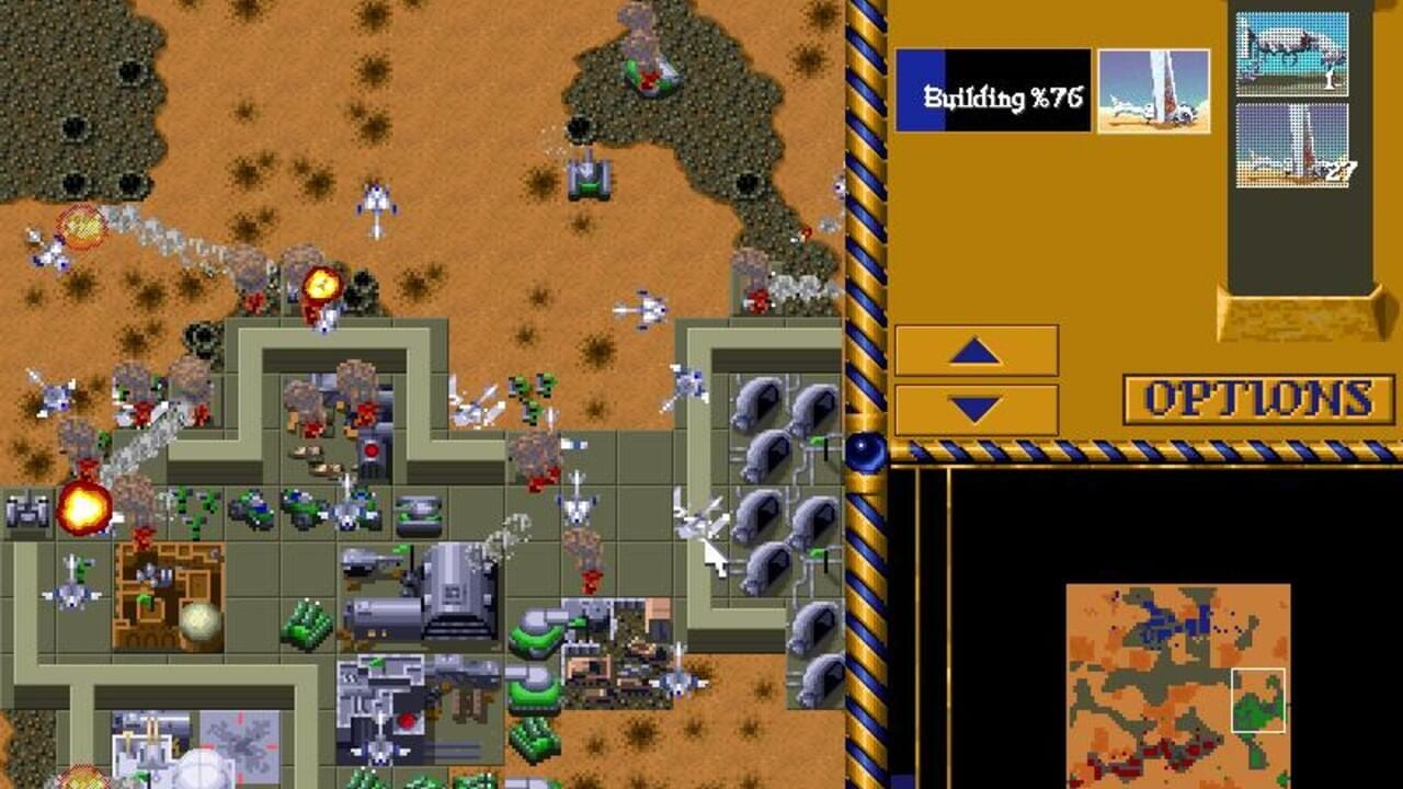 A top-down strategy game view displays a desert base with tan-colored sand terrain dotted with vegetation. Concrete-gray fortified structures with internal rooms occupy the center-left, including barracks, production facilities, and storage areas marked with items and units. Multiple armed units and harvesters scatter across the map. The right sidebar shows a yellow interface panel labeled 'OPTIONS' with up and down arrows, 'Building %76' progress text in a black window above, and three thumbnail screenshots. A blue-and-white striped border frames the right edge. The minimap in the lower-right corner displays an orange and green overhead view of the base layout. Yellow explosions and combat effects are visible near structures on the left.