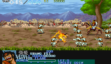 A side-scrolling beat-em-up gameplay scene displays a warrior character in the center executing a yellow flame attack against multiple enemies scattered across a brown dirt battlefield. Mountains and a settlement occupy the background under a blue sky. A green tree stands in the right foreground. The HUD shows score, health, and remaining lives in the upper corners, with a turquoise status bar at the bottom displaying character name and stage information. Pixel-art sprites and a 16-bit color palette characterize the arcade aesthetic.