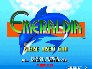 The Emeraldia title screen features a large blue dolphin sprite leaping over a red and orange banner containing the game's title in blue metallic letters. Below, yellow pixel text reads "PLEASE INSERT COIN" with additional text stating "©1993 NAMCO ALL RIGHTS RESERVED" and "NAMCO CREDIT ©". The background displays a light blue sky with white clouds. The overall art style uses bright colors typical of early 1990s arcade graphics with sprite-based character design.