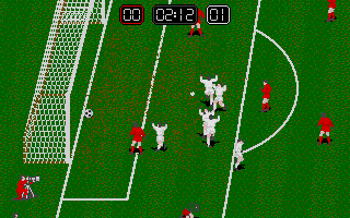 A top-down soccer game view displays a green pitch with white field markings, including a center circle and goal areas. Two white player sprites occupy the center field, while multiple red player sprites are scattered across the field. A white goal net is visible on the left side. The HUD at top shows a score of 02-12 with 01 displayed, indicating match time or player numbers. The pixel art uses a limited color palette with green grass texture and simple sprite designs typical of early 1990s DOS sports games.