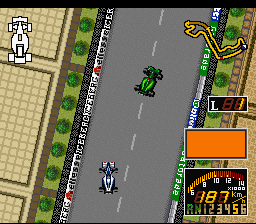 A top-down view of a racing track shows two Formula 1 cars on an asphalt road bordered by green grass and tan-colored buildings. The lead car in white is positioned lower on screen, while a green car follows behind in the center. The right side displays a minimap window with a yellow car icon and a horizontal damage or fuel gauge bar beneath it. The graphics use low-resolution sprites typical of early 1990s SNES racing games, with a tan checkered pattern visible on the left building and distinct color separation between road, grass, and structures.