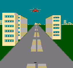 A top-down racing view displays a straight road with yellow dashed center lines stretching into the distance toward a sun symbol at the horizon. Two tan-colored apartment buildings with blue window details frame the left and right sides of the road. Green grass areas occupy the upper corners, and a teal sky fills the background. White text reading "FUEL" appears in the upper right corner. The scene uses a limited pixel-based color palette typical of early NES graphics, with clear sprite-based architecture and perspective scaling along the roadway.