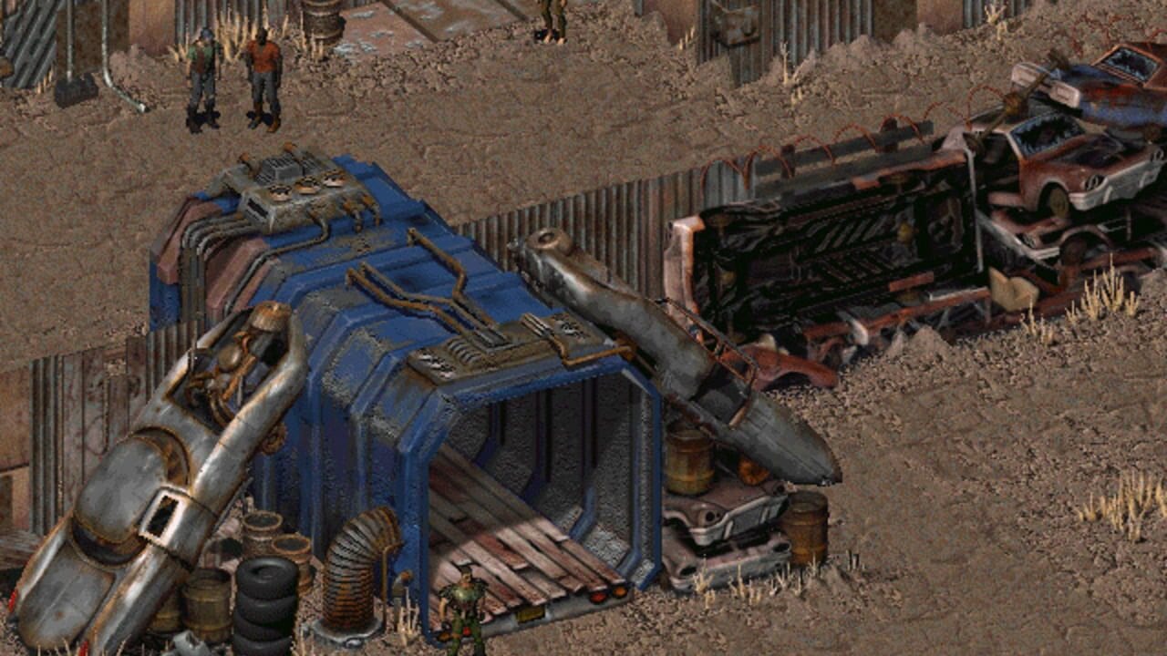 An isometric view of a post-apocalyptic junkyard shows a blue and gray military aircraft fuselage dominating the left side with exposed machinery and vents. Rusted vehicles and corrugated metal fencing scatter across the brown dirt ground. Two human figures stand in the upper area wearing red and brown clothing. The color palette emphasizes browns, blues, and grays with low-resolution sprite-based graphics typical of early 1990s DOS-era games.