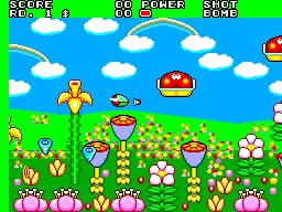 A yellow spaceship hovers in the center-upper area of a bright, colorful landscape filled with pink mushroom-like structures and green vegetation. The sky is bright blue with white clouds, and a red alien enemy floats in the upper-right portion. The HUD displays a score counter, lives remaining, and power meter at the top in yellow text against the green border. Pixelated sprites and a flat, vibrant color palette characterize the 8-bit visual style typical of Sega Master System games.