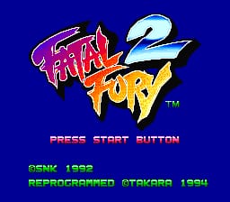 The title screen displays the Fatal Fury 2 logo in large pixelated text with red and yellow flames, set against a dark blue background. Below the logo sits a "PRESS START BUTTON" prompt in orange text. At the bottom, green text reads "GENKI 1992" and "REPROGRAMMED OTAKEB 1994," indicating the game's release information and modifications. The sprite-based graphics use a limited color palette typical of early 1990s SNES releases.