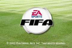 A soccer ball with the EA Sports logo and FIFA 4 branding sits centered on a green grass field background. The ball is white with red accents. At the bottom of the screen, copyright text reads '© 2002 ELECTRONIC ARTS INC. TIME SPORTS RESERVES.' The grass field fills the entire background with horizontal striped texture typical of GBA sprite scaling.