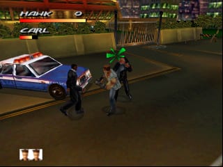 A nighttime street scene displays two player characters standing near a blue and white police car on an urban asphalt surface. Health bars labeled 'HAWK' and 'CARL' appear at the top of the screen with green numerical values. Store signs and awnings are visible in the background, rendered in warm yellow and brown tones. The scene uses a low-polygon 3D art style typical of N64 games, with flat-shaded geometry and visible draw distance fog. A white 'H H' indicator appears in the lower-left corner.