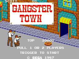 The title screen displays "GANGSTER TOWN" in large red letters centered on a brick building facade with blue and yellow windows. A brown-clothed character figure stands in the lower left against a gray street. Below the title, white text reads "TOP" with a score counter showing "10000", followed by "PULL 1 OR 2 PLAYERS" and "TRIGGER TO START" with a Sega 1987 copyright notice. The scene uses a limited pixel art palette with orange brick, blue sky, and brown sprites typical of early SMS graphics.