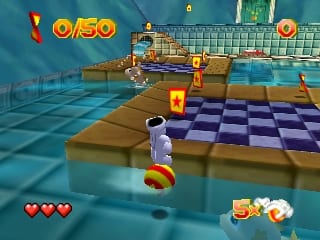 A character in white clothing stands on a blue checkered floor in a water-filled level, facing a series of brown and blue platform structures. The scene uses a 3D polygonal art style with a blue-tinted underwater atmosphere. The HUD displays three red hearts on the left, a score counter showing 0/50 in the upper left, a circular power indicator in the upper right, and collected items shown in the lower right corner. Yellow torch-like objects are visible on some platforms and in the level design.