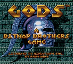 The title screen displays the word "GODS" in large gold lettering at the top, with a blue stone face or mask occupying the center-right portion of the screen. Below the face appears "BITMAP BROTHERS GAME" in yellow text. A teal brick wall pattern forms the background. At the bottom, smaller yellow text reads "PRESS START TO BEGIN" and credits mentioning The Bitmap Brothers and Renegade. The overall color palette features teals, golds, and blues typical of early 1990s SNES graphics.