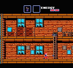 A two-story brick building interior with orange-red walls and blue-framed windows dominates the center. A small sprite character stands on the lower floor, surrounded by furniture including chairs, tables, and a fireplace. The upper floor mirrors the lower layout with similar windows and furnishings. A vertical elevator shaft runs down the center-right. The HUD displays "ENERGY" in the top-right corner with a health bar. The black background and low-resolution pixel sprites are characteristic of NES-era graphics.