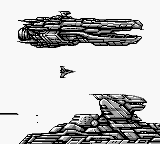 Two pixelated spacecraft are shown against a black background, positioned in the upper and lower portions of the screen. The upper vessel appears as a detailed, jagged silhouette with angular protrusions, while the lower craft has a similar geometric design. A small triangular enemy or projectile sprite floats between them in the center. The graphics display the low resolution and monochromatic style typical of Game Boy hardware from the early 1990s.