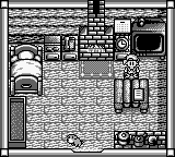 A top-down view of a farm layout rendered in monochrome Game Boy graphics. The scene displays a brick farmhouse in the upper-left, various farm structures including what appears to be a barn or shed on the right side, fenced areas, and scattered crops or vegetation throughout the plot. UI elements and status information are visible along the edges of the screen, typical of early Harvest Moon farming simulations. The pixel art uses the Game Boy's limited monochrome palette with clear black outlines defining structures and terrain.