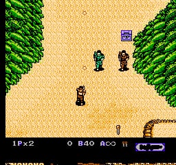 A top-down view of a sandy arena bordered by green forest on both sides. Four pixelated soldier sprites in dark uniforms are scattered across the beige terrain, with one positioned lower-left, two in the center-right area, and one in the upper-center. The HUD displays player health at top-left reading "1P x2", ammunition count "O B40", and additional stats on the right side. The scene uses a limited 8-bit color palette with brown sand, bright green trees, and monochrome UI elements.