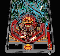 A pinball table layout displays a central circular target with radiating orange and yellow segments at the top center, flanked by two red flippers at the bottom. Blue ramps curve along the sides with bumpers and roll lanes scattered across the playfield. A red W logo appears in a black rectangle at the bottom center, with additional score readouts in the lower corners. The table uses a teal and red color scheme against a dark background.
