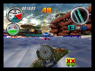 A speedboat races across turquoise water toward an explosive scene with a large fireball erupting from a coastal structure in the background. The HUD displays a compass in the upper left, a speed gauge in the upper right showing maximum velocity, race position indicators reading "1 OF 8" in yellow text, and a timer showing "00:16:03" at the top. A large weapon or power-up icon with "XX" marks appears in red at the bottom right. The sky shows dramatic storm clouds, and the scene uses a bright, detailed 3D art style typical of early 2000s arcade racing games.