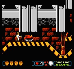 A crash dummy character stands on a yellow and black striped platform in the center of the screen, positioned above red brick walls. The dummy faces right, rendered in orange and yellow pixels. Four golden coin or item icons line the bottom left corner. The HUD displays a health bar, score counter reading 000100, and a lives indicator in the lower right. Dark brick background fills the upper portion with a black parallax sky, while yellow caution tape frames the platform edges. Sprite-based 8-bit NES graphics with limited color palette of orange, yellow, red, black, and white.