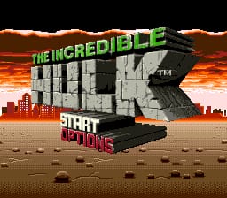The Incredible Hulk title logo dominates the center in large white and green letters, positioned over a pixelated cityscape silhouette rendered in orange and brown tones. Below the logo, a stylized Hulk fist emerges from desert sand with scattered rocks and debris. The word "START" appears in magenta text at the bottom, with additional menu options below it. The background features a burnt orange sky with darker brown cloud formations at the top. The overall aesthetic uses typical SNES-era 16-bit sprite graphics with a warm color palette dominated by oranges, browns, and sandy tones.