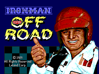 A man wearing a red racing helmet and white racing suit with red accents appears in the right half of the screen, making a fist gesture toward the viewer. The title "IRONMAN OFF ROAD" is displayed in large yellow capital letters across the upper portion against a dark blue background. A yellow and red circular logo appears to the left of the title. The bottom of the screen shows copyright text reading "© 1989 All Rights Reserved Leland Corp" in small white text. The overall color palette consists of blue, red, yellow, white, and flesh tones typical of late 1980s arcade graphics.