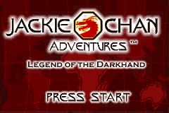 The title screen displays the Jackie Chan Adventures logo in white text with a red circular icon containing the number 2, centered at the top. Below it reads "Legend of the Darkhand" in gray text. The background is a dark red gradient with subtle texture. At the bottom, white text reads "Press Start". The overall layout uses a symmetrical design against the maroon backdrop.