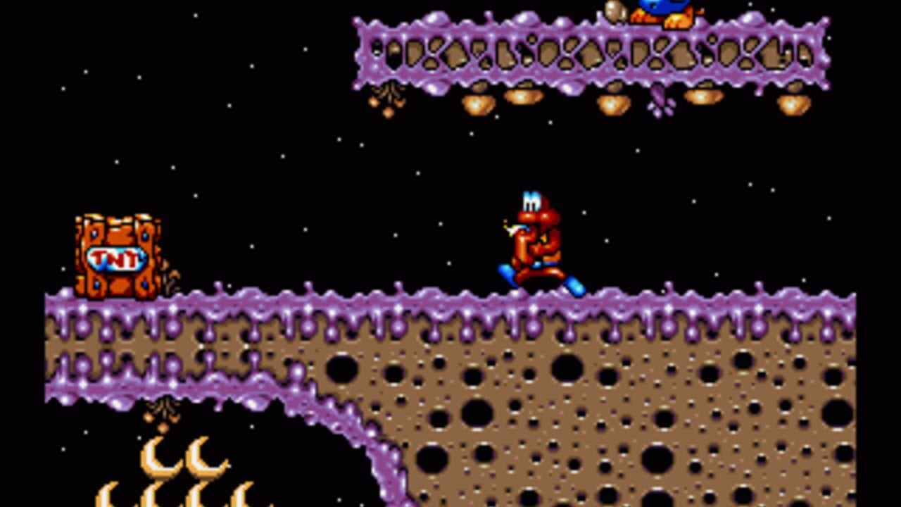 A red character with white hair stands on a brown textured platform with purple-tinted edges in a space environment. An orange TNT crate sits to the left on the platform. At the top, a purple structure with black hexagonal cutouts spans the screen width, with orange dangling projectiles below it. A smaller purple structure hovers at the top right with a golden object. White stars dot the black starfield background, and yellow flame-like sprites appear in the lower left corner. The scene uses 16-bit sprite graphics with a brown-and-purple color scheme.