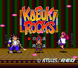 The title screen displays "Kabuki Rocks!" in large orange and blue letters centered at the top. Below the logo, a wooden stage floor stretches across with a dark vertical-striped curtain backdrop. Three sprite characters stand on the stage: a performer in white clothing on the left, a central figure in traditional Japanese dress, and a character in pink on the right. Small pink circular objects float in the air above. The Atlus/Red Entertainment copyright notice appears at the bottom right in white text.