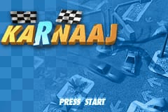 The title screen features the large yellow "KARNAAJ" logo at top-center with checkered racing flags in black and white beside it. Behind the text, a blue-tinted background displays a stylized overhead view of a racing track with multiple vehicles positioned on the road. At the bottom of the screen, white text reads "PRESS START" in a sans-serif font. The overall color scheme uses shades of blue for the background with bright yellow for the title text, typical of Game Boy Advance visual presentation.