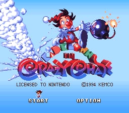A colorful clown character in red and blue clothing sits atop stacked red and blue letters spelling the game title against a bright blue sky. White puff clouds appear on the left side, while a purple ball floats to the right of the clown. Below the main graphic, copyright text reads "LICENSED TO NINTENDO" and "©1994 KEMCO". Two menu options, "START" and "OPTION", are positioned in white text at the bottom of the screen.
