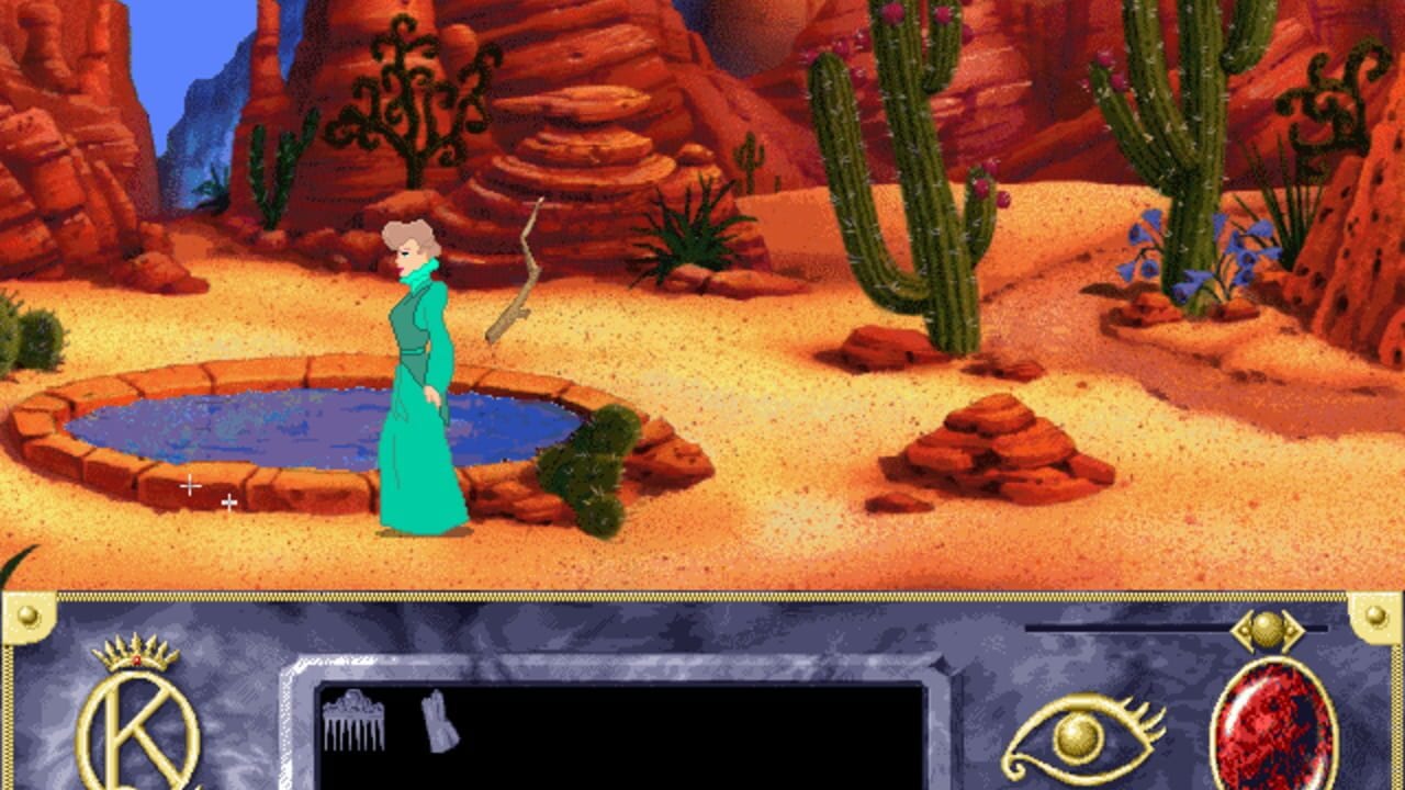 A woman in a teal dress stands in a desert landscape with red rock formations, tall green cacti, and scattered boulders. A circular blue pool of water sits to her left with a stick nearby. The sandy ground is tan and dotted with brown rocks. The sky is bright blue. At the bottom, a UI panel displays inventory icons on the left including a crown and comb, an eye symbol in the center-right, and a red gemstone icon on the right. A black inventory window is visible in the panel's center.