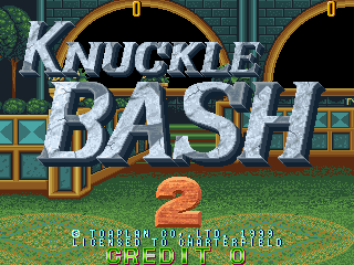 The title screen displays 'KNUCKLE BASH 2' in large white pixel lettering with a metallic gold outline effect. Below the title is a large orange numeral 2. The background shows a side-scrolling beat-em-up stage with teal-colored brick walls, a brown tunnel entrance, and green grass terrain with scattered vegetation. A yellow-bordered doorway is visible on the right side. At the bottom, white text reads 'START GAME' and score information appears in the lower-left corner. The overall color palette uses bright greens, oranges, and teals typical of late-1990s arcade hardware.