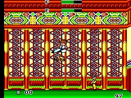 A player character stands in the center of an ornate Chinese-style interior with red pillars and decorative yellow and red lattice patterns. The scene displays a score of 100 at the bottom left and 570 at the bottom right. Pixelated sprite art shows a vertical corridor with repeating architectural elements and warm earth-tone colors. The interface features a simple HUD with numerical displays typical of early 1980s arcade-style games. The background uses a limited color palette of reds, yellows, and browns with a brick pattern border framing the play area.