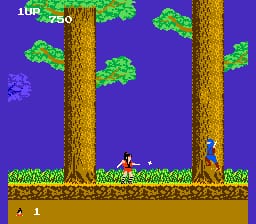 A ninja character stands on a brown dirt platform in the center-lower portion of the screen, surrounded by two tall brown tree trunks against a purple sky. Green foliage clusters sit atop and between the trees. A blue enemy figure appears on the right side of the platform. The top-left corner displays a score counter and additional UI elements in a yellow font. The sprite-based graphics use a limited NES palette with bright greens, browns, and purples against solid backgrounds, typical of mid-1980s action game visuals.