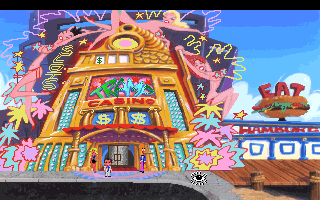 A colorful casino building facade dominates the center, featuring bright orange and yellow walls with multiple window rows containing slot machine imagery. Pink and purple decorative elements surround the structure. A sign reading "FAZ" appears in the upper right corner in red letters. The sky is bright blue with a white cloud visible. The art style uses vibrant colors typical of early 1990s PC graphics with a flat, painted aesthetic. A wooden structure is partially visible at the bottom right edge.
