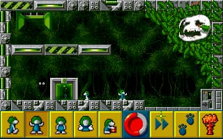A side-scrolling level displays multiple lemmings in a forested environment with dark green pixelated trees and black shadows. The playfield shows several small lemming sprites moving through terrain with stone-textured platform edges. A control panel at the bottom features seven lemming-faced icons in yellow squares, a large red circular button, blue arrow buttons, and an orange creature icon, all representing available tools and actions. The top interface shows resource counters and icons. The visual style uses low-resolution sprites and a muted green, gray, and black color palette typical of early 1990s DOS platformers.