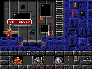 A split-screen gameplay view shows two levels of a stone dungeon. The upper half displays a gray industrial chamber with metal doors, platforms, and a character sprite in orange-red armor on the left side near a "U.K. GUST" sign. The lower half shows a darker underground cavern with brown stone textures, orange-red enemy creatures, and scattered crates. Both screens feature blue-tinted background machinery and metallic elements. The pixel art uses a 16-bit sprite style with distinct character and enemy silhouettes against contrasting colored environments.