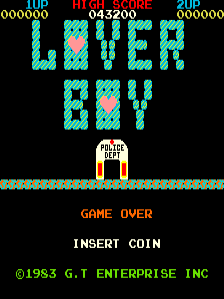 The game-over screen displays "LOVER BOY" in large cyan pixelated letters centered on a black background. Below sits a small sprite of a figure in an orange and white outfit standing on a tiled platform. Text reading "GAME OVER" appears in orange, followed by "INSERT COIN" in white. The top of the screen shows score information in cyan and red, with "©1983 G.T ENTERPRISE INC" in green at the bottom.