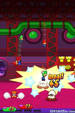 A colorful battle scene displays two Mario brothers in the center of a red mechanical factory interior with green pipe structures overhead. A large yellow explosion effect with "Great!" text occupies the middle-right, indicating a successful action. Enemy sprites appear in the lower portions of the screen. The bottom of the display shows a green health/status bar on the left side and colorful UI elements. The art style uses bright, saturated colors typical of Nintendo DS sprite-based graphics with a magenta-tinted background environment.