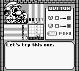 A Game Boy screen displays a nonogram puzzle grid in the center with a partially completed black-and-white pattern. Mario's head sprite appears in the upper-left corner. The top displays progress indicators and numbered clue rows. The right side shows a vertical menu with options including a settings icon, chest, and MENU button. Below the grid sits the text "Let's try this one." The monochrome display uses the Game Boy's characteristic dot-matrix aesthetic with crisp pixelated UI elements.
