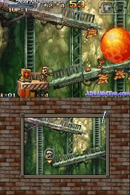 A dual-screen Nintendo DS gameplay view of Metal Slug 7 showing two vertically-stacked level layouts. The upper screen displays an industrial facility with green-toned machinery, metal scaffolding, and a large fiery explosion in the upper right corner. A soldier character stands on metal platforms with enemy units visible. The lower screen shows a similar facility layout with the player's character centered, surrounded by mechanical structures and platforms. The HUD displays score, lives counter, weapon icons, and other gameplay information around the edges. Sprite-based graphics with detailed backgrounds rendered in muted greens and browns characteristic of early 2000s arcade-style handheld games.
