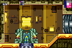 A blue-suited character stands in the center of an industrial corridor with yellow and brown metallic walls and doorways. The character faces right, positioned on a dark floor panel. The left side displays a HUD with health and ammunition indicators, while the top-left corner shows the game title and a small USA flag icon. Yellow cylindrical structures and rectangular wall panels create a utilitarian sci-fi environment with visible depth through multiple doorways receding into the background. The overall color palette consists of muted yellows, browns, blues, and grays rendered in 16-bit sprite graphics.