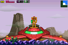A large red and gold mechanical boss with a spherical central body sits on a purple terrain dotted with dark rocks, set against a lavender sky with two tall stone formations flanking it. The Game Boy Advance UI displays health and energy meters in the top-left corner, with a small inventory icon in the top-right. The sprite-based graphics show the characteristic 16-bit pixelation and color palette typical of GBA releases.