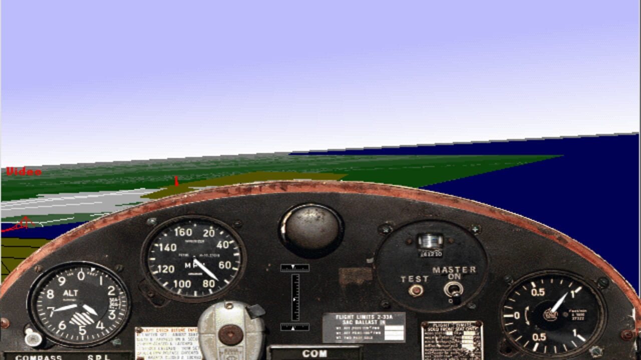 An aircraft cockpit view with a brown-rimmed dashboard displaying multiple analog gauges including an altimeter on the left, airspeed indicator in the center-left, compass at bottom-left, and test/master switch panel on the right. A spherical control knob sits prominently in the center. The windscreen shows a runway with grass terrain, scattered buildings, and a blue sky above. Instrument labels and placard text are visible on various gauge faces.
